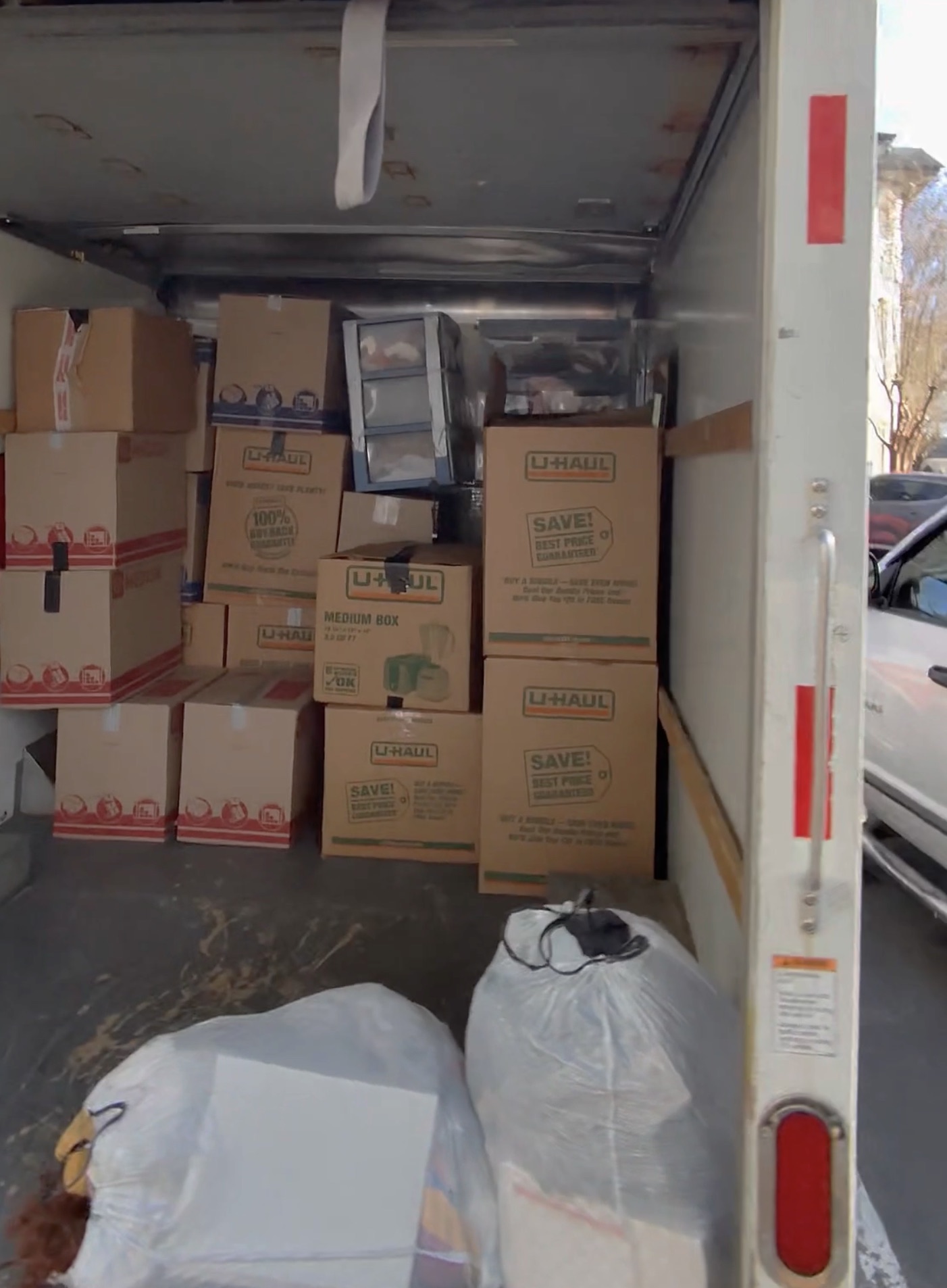 Stacked moving boxes and wrapped furniture packed inside a moving truck