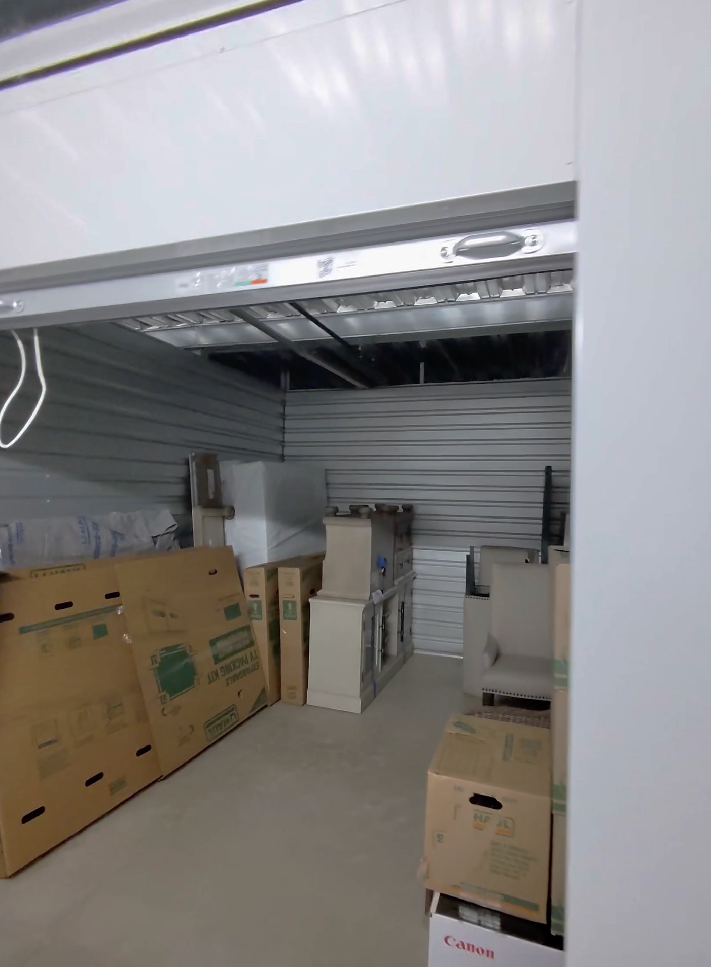 Wrapped furniture and moving boxes loaded inside a storage unit
