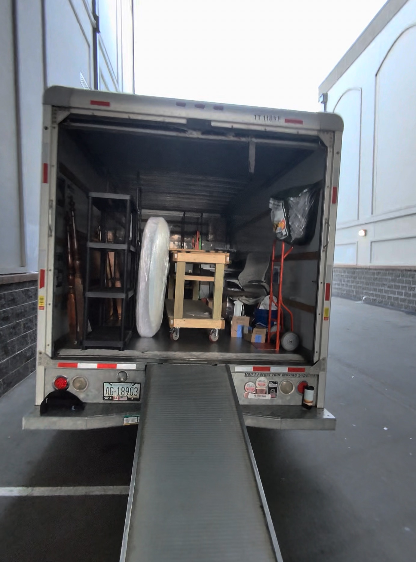 Furniture and boxes loaded up the ramp into the moving truck